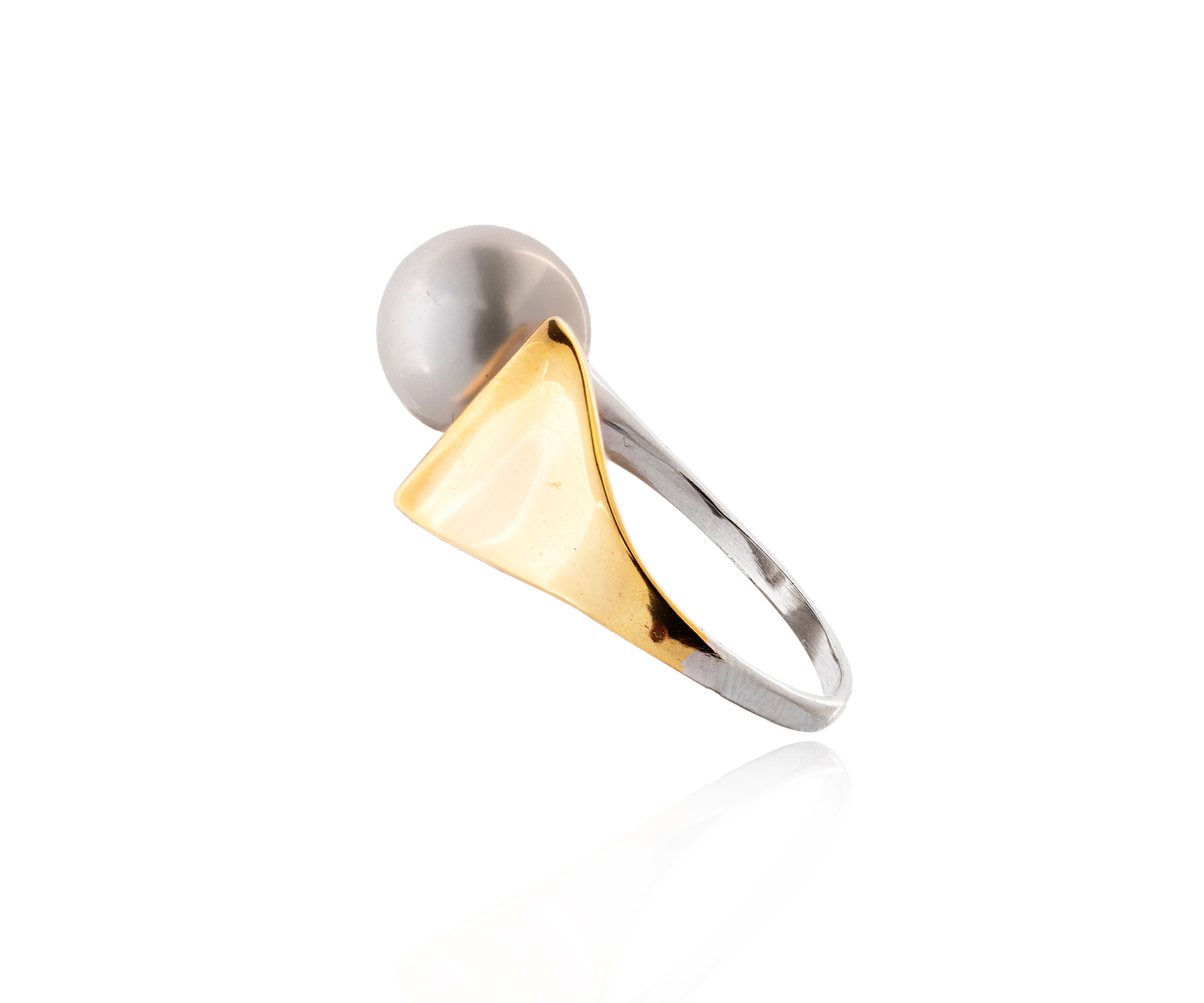 Anillo plateado con ala dorada y perla cultivada.
