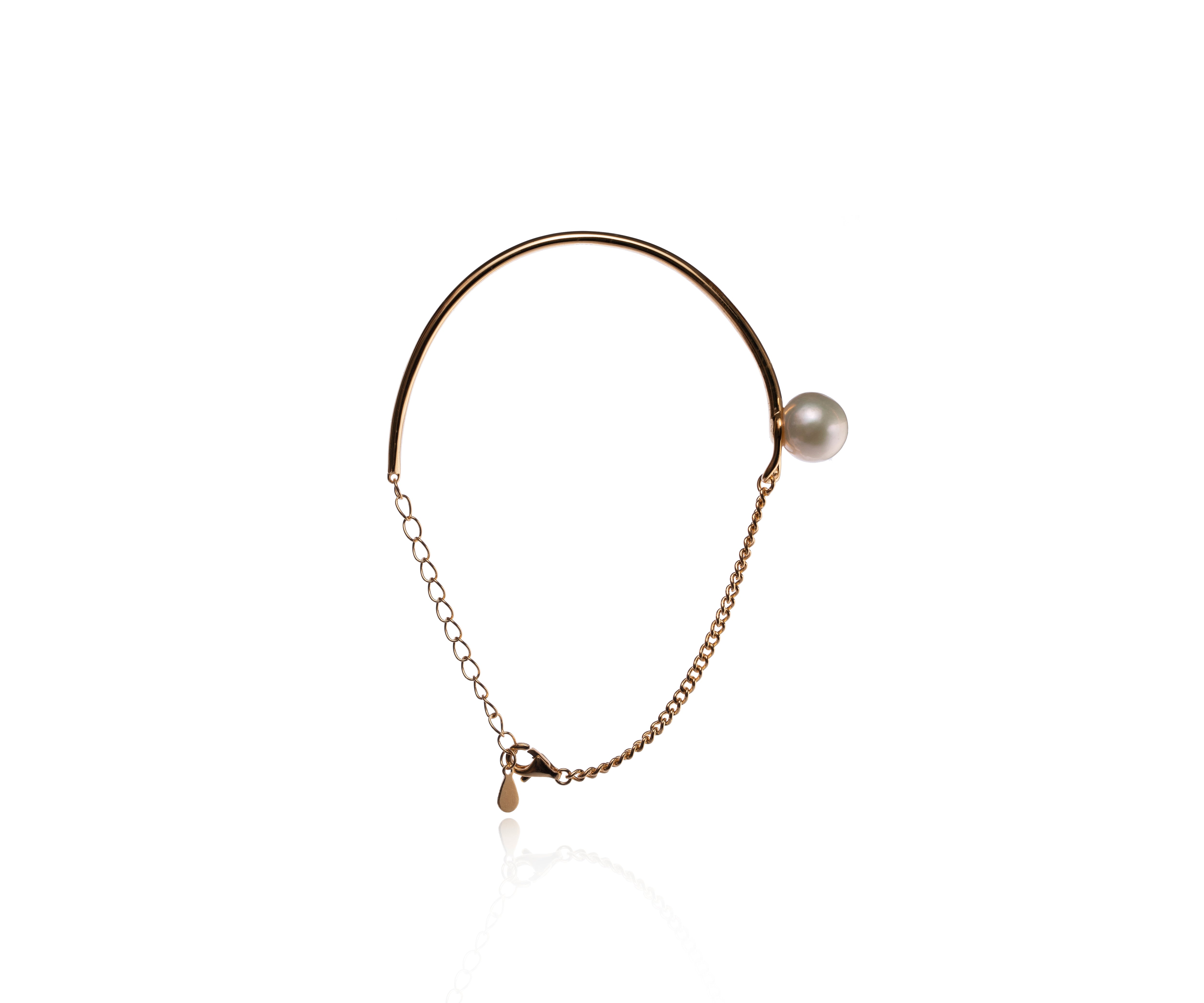 Pulsera rígida dorada tipo brazalete con perla cultivada.