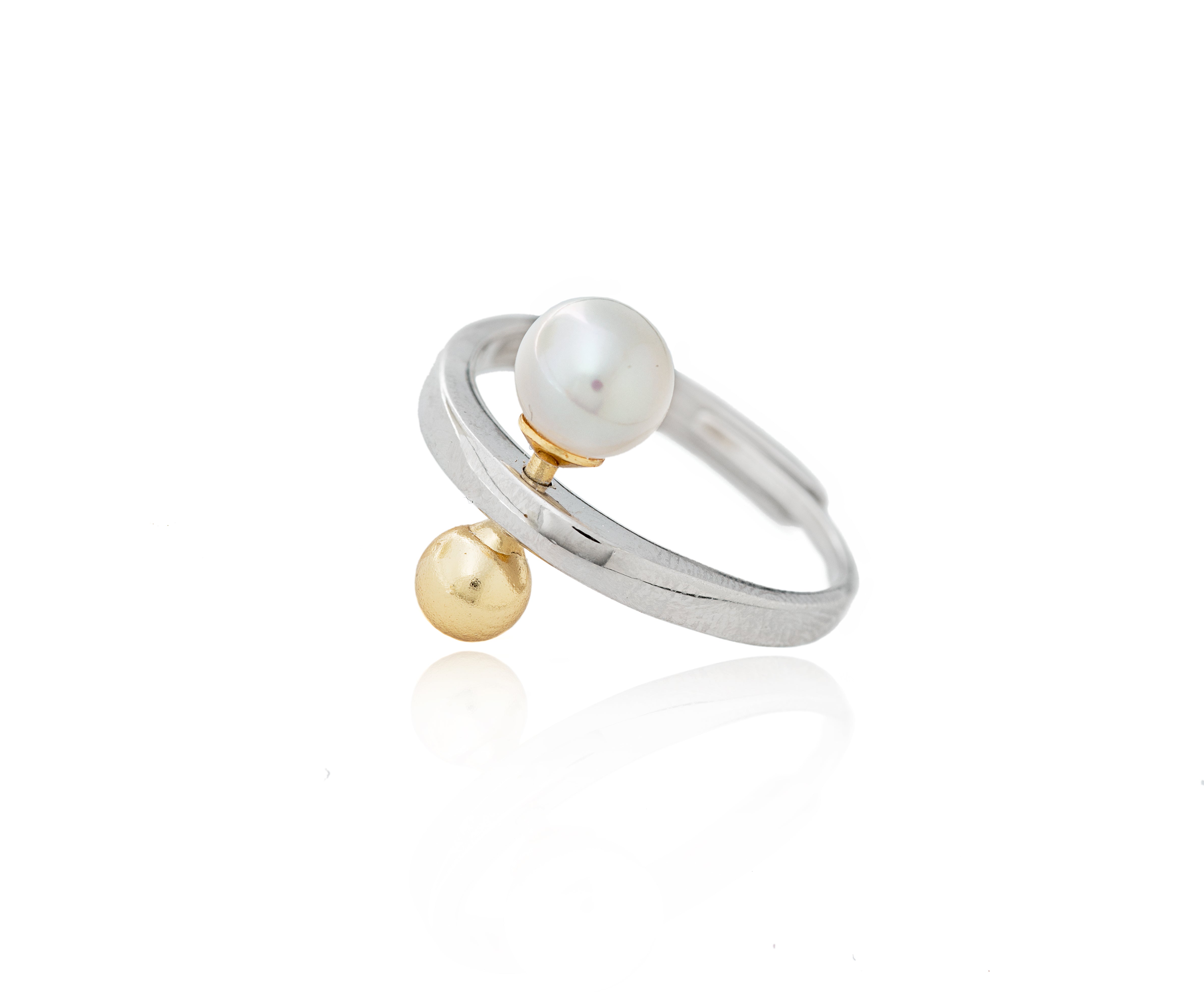 Anillo bicolor con perla cultivada y esfera dorada.