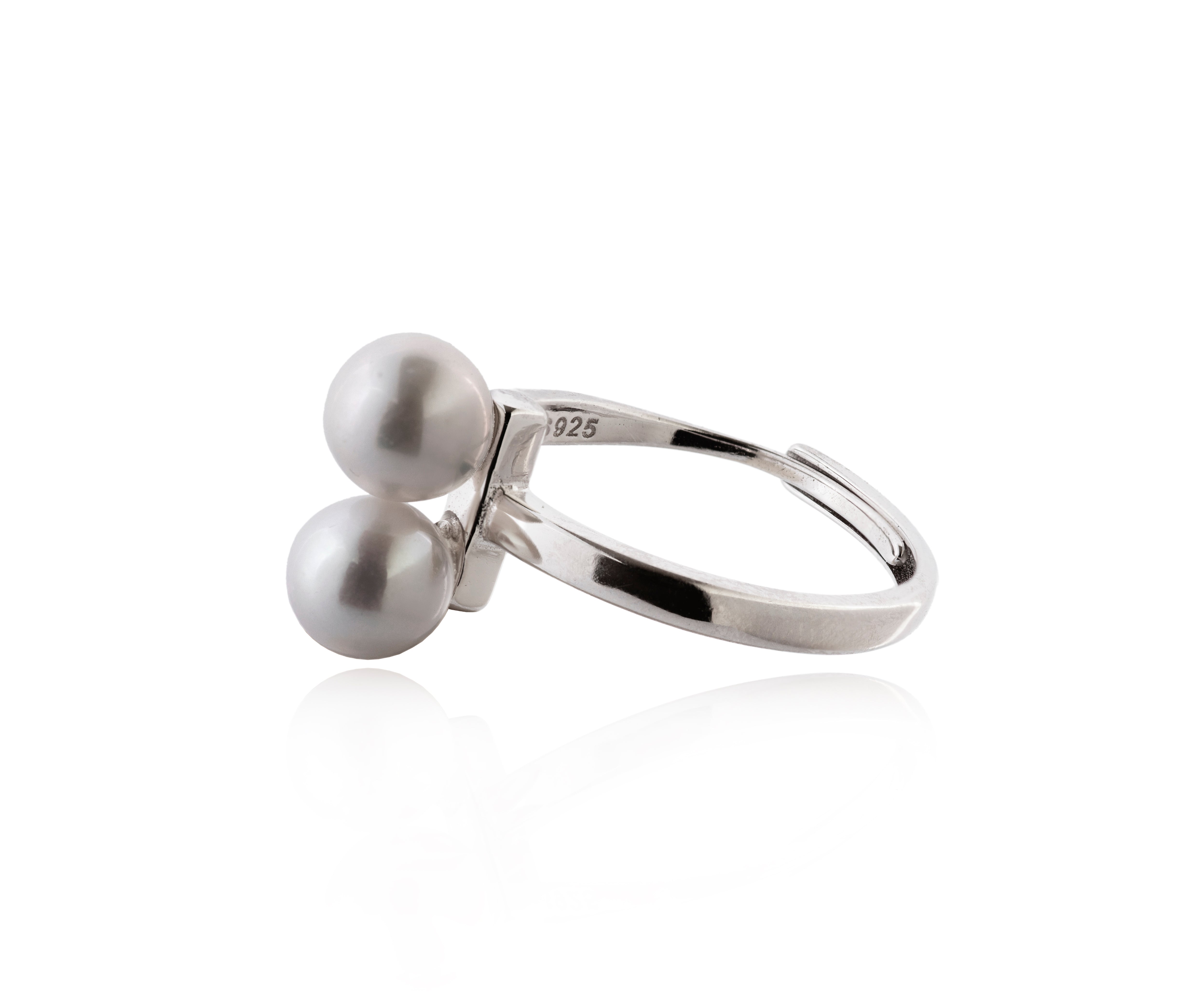 Anillo plateado con dos perlas gemelas.