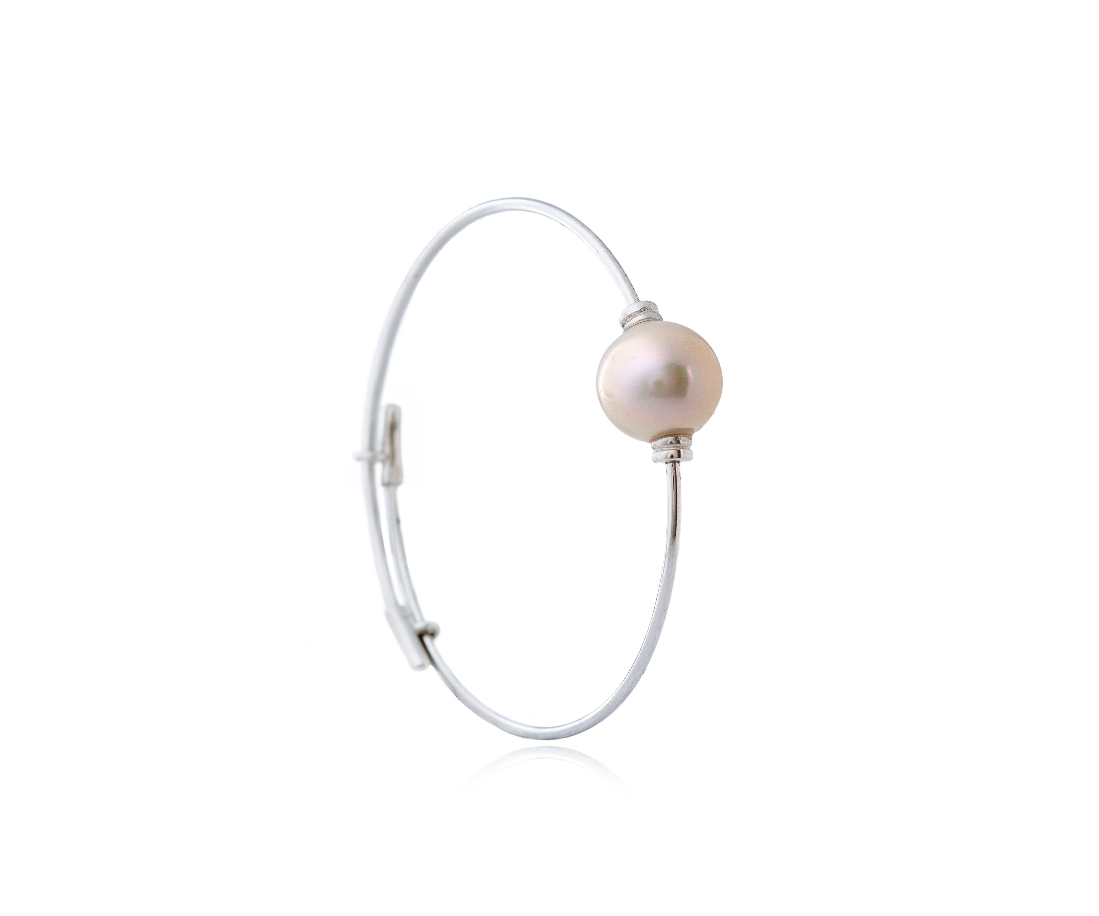 Pulsera rígida plateada con perla central.